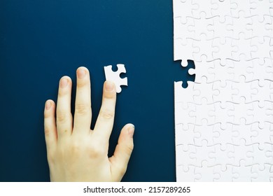 Intellectual puzzles. The puzzle empty. The hand puts together puzzle pieces. Brain training. - Shutterstock ID 2157289265