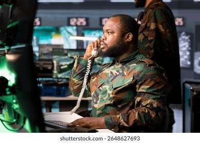 Intelligence officer using communication systems to call in air strikes on enemy troops. Military dispatcher making telephone call to request air support for ground soldiers