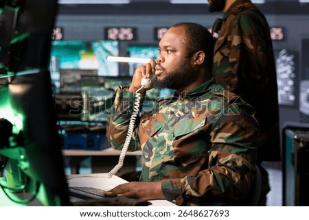 Intelligence officer using communication systems to call in air strikes on enemy troops. Military dispatcher making telephone call to request air support for ground soldiers