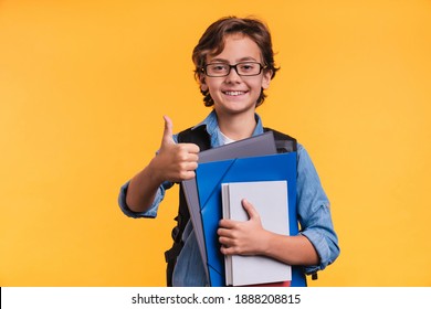 Intelligent 10s caucasian boy in glasses and casual attire with books for studing at school isolated over yellow background - Shutterstock ID 1888208815