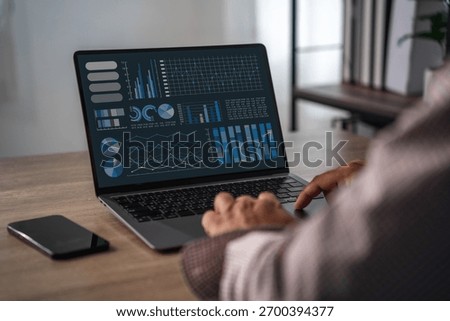 Intelligent analytics on screen with graphs and charts as business team reviews financial statement, discusses results, and aligns management decisions.