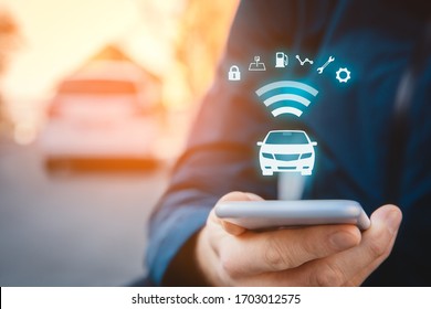 Intelligent car app on smart phone concept, intelligent vehicle and smart cars concept. Person with smart phone on street, car in background and wireless communication with car.