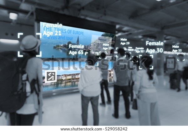 Intelligent Digital Signage , Augmented reality\
marketing and face recognition concept. Group of people watch\
interactive artificial intelligence digital advertisement in retail\
shopping Mall.
