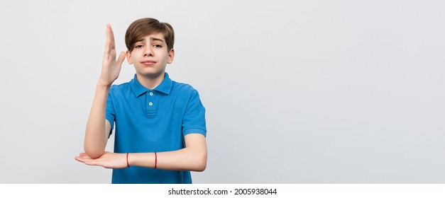 Intelligent Enthusiastic Teen Boy Raises His Hand Up With A Happy Smile To Attract Attention And Answer A Question, Isolated On Light Gray Background