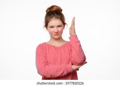 Intelligent Enthusiastic Teen Girl Raises Her Hand Up To Attract Attention And Answer A Question. Body Language, Signs And Gestures. Studio Shot, White Background