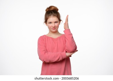 Intelligent Enthusiastic Teen Girl Raises Her Hand Up To Attract Attention And Answer A Question. Body Language, Signs And Gestures. Studio Shot, White Background