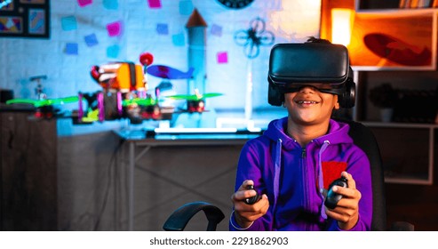 Intelligent indian kid controlling drone by wearing VR or virtual reality headset and controller at home - concept of modern technology, futuristic and innovation. - Powered by Shutterstock