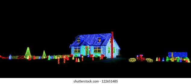 Intense Bright Colors LED Christmas Light Show And Display On A House And Its Yard For Festive Holiday Illuminations On A Black Night