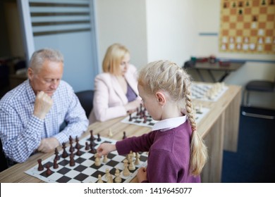 Intense Chess Game Where Adult Experienced Sportsman Playing With School Girl With Braided Hair