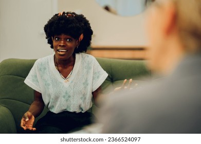 An intense client is explaining her problems in a session with a psychotherapist. An african american woman is sitting in the office with a psychotherapist and discussing issues.