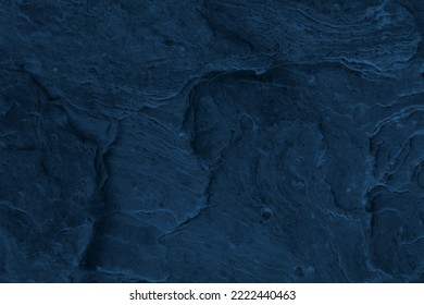 intense dark blue abstract background for advertising wallpaper.  Sea rock texture seen from above. Surface full of layers, lines, holes, bumps and other traces of natural water and wind erosion. 