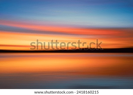 Intense impressionist sunrise for background use across calm water