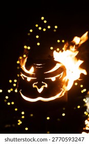 Intense Orange Flame Inside a Devilish Mask Decoration at Night.
