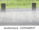 Intense rainfall drenches the cobblestone path, causing water to splash in all directions. Puddles form as drops create ripples, enhancing the tranquil atmosphere.