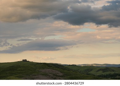 An intense sunset with light illuminating the cloudy sky over a typical Tuscan landscape of green hills and cypress trees, siena, tuscany