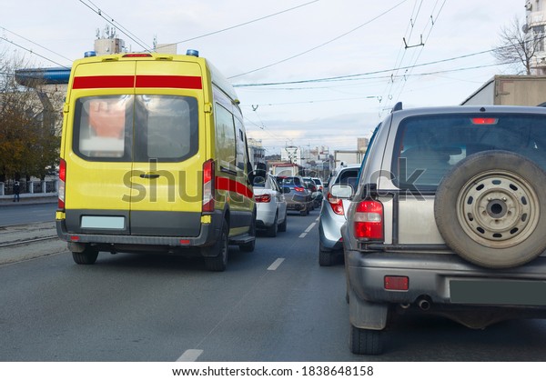 An intensive care ambulance moves\
in a stream of cars along a city street to a patient during\
quarantine for the covid-19 coronavirus pandemic. blurred\
focus