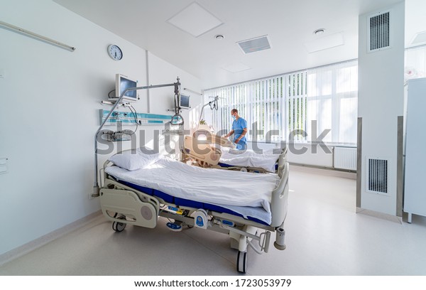 Intensive Care Unit. Very sick man lying on the\
bed. Doctor checks his vital\
signs
