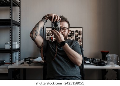 An intent photographer composes a shot with his camera, his focus evident as he looks through the viewfinder, framing a moment in time - Powered by Shutterstock