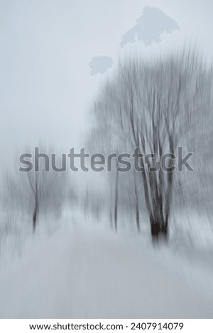 Intentional camera movement (ICM) image of a dream like view of snow covered road in winter created by motion blur, Haltiala, Helsinki, Finland.
