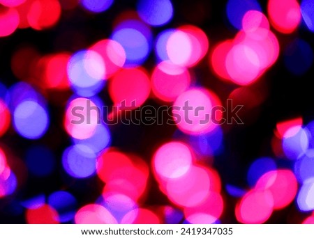 intentionally blurred background of many colorful lights of red fuchsia blue colors ideal as hyptonic or dreamy background