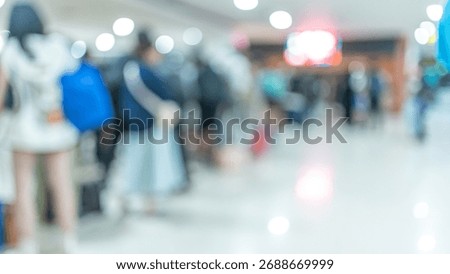 An intentionally blurred and defocused image capturing a crowd of people waiting in line, suggesting a busy airport terminal or transportation hub.