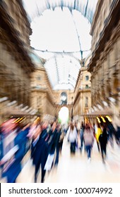 Intentionally motion blurred creative image of people walking in Galleria Vittorio Emanuele II in Milan, Italy. Galleria Vittorio Emanuele is one of the most famous landmarks in Milan.