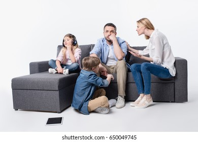 interacting caucasian family sitting on sofa together isolated on white