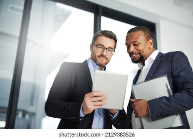 Interactive collaborations with the help of wireless technology. Shot of two businessmen using a digital tablet together at work. - Powered by Shutterstock