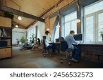 Interactive co-working space. Bustling co-working environment with young multiethnic people working and studying. Concept of business and education, co-working space, modern office