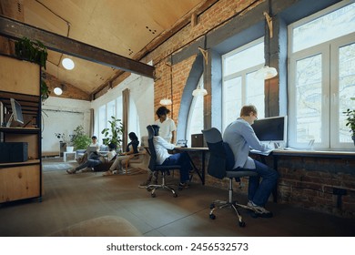 Interactive co-working space. Bustling co-working environment with young multiethnic people working and studying. Concept of business and education, co-working space, modern office - Powered by Shutterstock