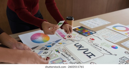Interactive Design Elements in UX UI. A group collaborates around design materials, examining various design components.