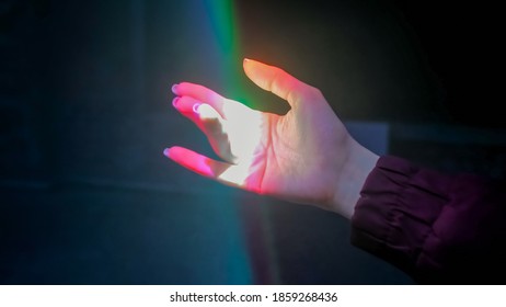 Interactive Exposition In Science Museum Or Exhibition: Bright Laser Light Installation. Woman Moving Hand Under Colorful Illumination - Close Up View. Optical And Visuals Concept