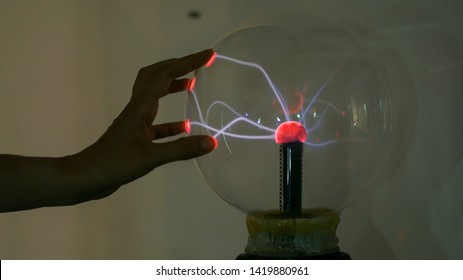 Interactive Exposition In Science Museum. Woman Touching Plasma Ball. Electricity And Physics Concept