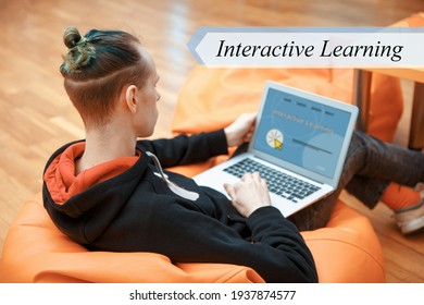 Interactive Learning concept. A young man sits in an armchair and works at a computer.