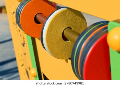 Interactive playground activity panel with rotating elements, close up. Sensory play equipment, child development, inclusive playground and educational activity concept.