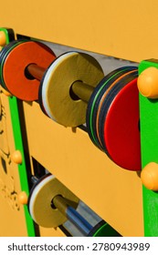 Interactive playground activity panel with rotating elements, close up. Sensory play equipment, child development, inclusive playground and educational activity concept.