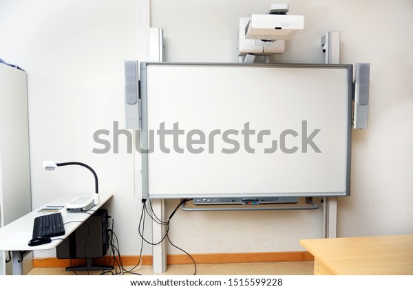 Interactive whiteboard with beamer\
as a modern school blackboard in the classroom, copy\
space