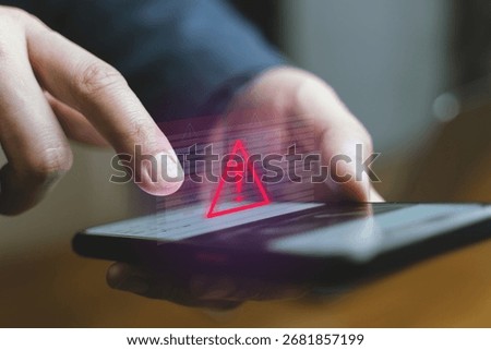 Interacts with a smartphone, triggering a red digital warning triangle, suggesting a system error or security breach.