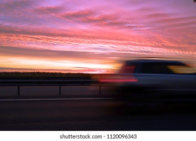 Interchange of the highway. Dramatic sky, fiery sunset. The lights on the road.