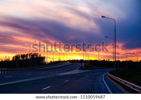 Interchange of the highway. Dramatic sky, fiery sunset.