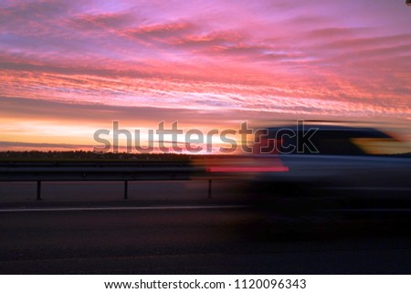 Interchange of the highway. Dramatic sky, fiery sunset. The lights on the road.