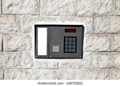 An intercom doorbell and access code panel on the wall. - Shutterstock ID 168755822