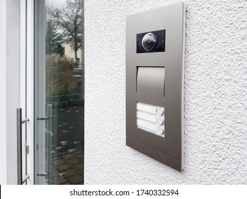 Intercom On White Textured Wall. Facade House With Glass Door. Close Up