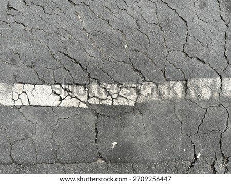 Interconnected cracks, highlighting the need for road maintenance.
