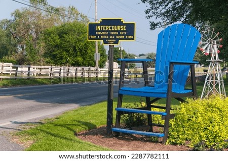 The intercourse pennsylvania sign near a large blue chair in Lancaster County. 