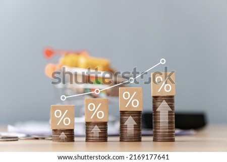 Interest on stack of coins stacked on table with percentage icon on wooden wooden block with white illustration showing interest rate increase financial concept.