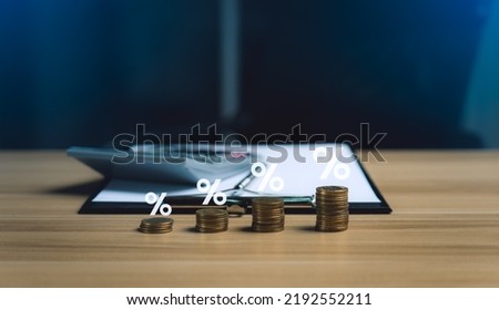 Interest rate and dividend concept. income and return on investment as a percentage. Return on mutual funds and stocks. long term investment for retirement. pile of coins, calculators and notebooks