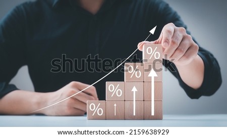 Interest rate and dividend concept, wooden block with percentage symbol and up arrow, return on stocks and mutual funds, long term investment for retirement.
