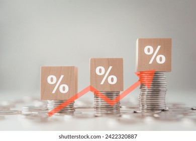 Interest rate finance and mortgage rates. Wood block with percentage sign on stack of coins and rise of arrow up, financial growth, interest rate increase, inflation, sale price and tax rise concept.