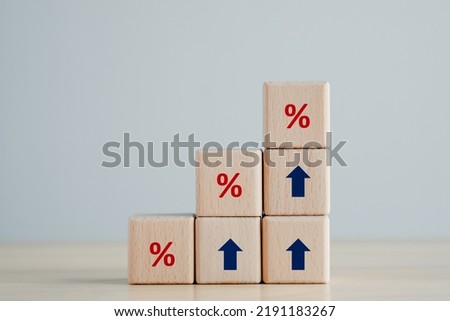 Interest rate finance and mortgage rates concept.  Wooden blocks with blue arrow up and red percentage sign, financial growth, interest rate increase, inflation, sale price and tax rise concept.